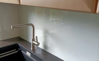 Küche in Bonn mit Dekton Arbeitsplatten Kelya und Glasrückwand RAL-Farbe 9003 Signalweiß