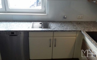 Küche in L-Form mit den Granit Arbeitsplatten Mondariz