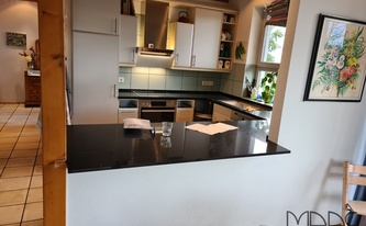 Küche in Bonn mit Quarz Arbeitsplatten und Wischleisten Mirror Black