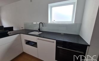 Granit Arbeitsplatten Impala Scuro und Glasrückwand RAL-Farbe 9016 in Koblenz montiert