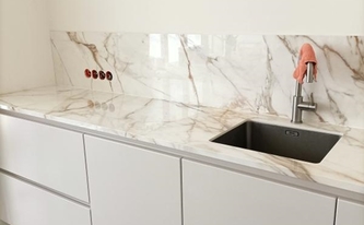 Küchennische mit Porcelanosa Arbeitsplatten und Rückwände Calacatta Gold in Köln montiert