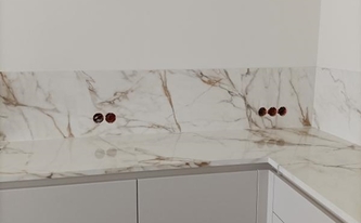 Marmoroptik der Küchennische mit Porcelanosa Arbeitsplatten und Rückwände Calacatta Gold