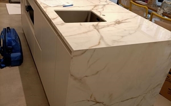 Kücheninsel mit Küchennische mit Porcelanosa Arbeitsplatte und Seitenwangen Calacatta Gold