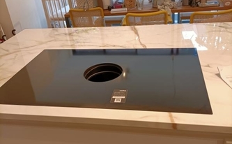 Küchennische mit Porcelanosa Arbeitsplatte Calacatta Gold mit flächenbündigen Ceranfeld