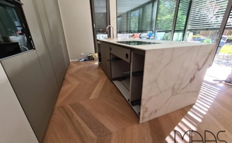 Kücheninsel in Köln mit Porcelanosa Arbeitsplatten und Seitenwange Calacatta Gold