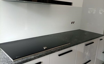Küche in Odenthal mit Granit Arbeitsplatten Steel Grey und Glasrückwand 9016 Verkehrsweiß