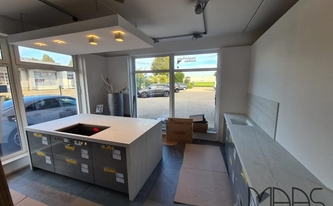 Küche im Küchenstudio mit Dekton Arbeitsplatten, Seitenwangen und Rückwand Neural