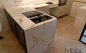 Küche in Wesseling mit Porcelanosa Arbeitsplatten und Seitenwangen Calacatta Gold