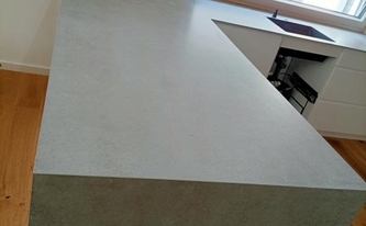 Auf Gehrung verklebte Porcelanosa Arbeitsplatte und Seitenwange Bottega Acero