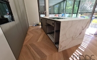 Kücheninsel in Köln mit Calacatta Gold Porcelanosa Arbeitsplatte und Seitenwangen