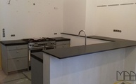 Küche in Köln mit Nero Assoluto Zimbabwe Granit Arbeitsplatten und Schürze