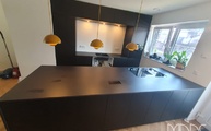 Schwarze IKEA Küche mit Domoos Dekton Arbeitsplatten und Seitenwange