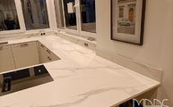 Montage der Calacatta Oro Infinity Arbeitsplatten und Wischleiste an die Wand montiert