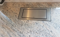 Flächenbündiger Ausschnitt für die versenkbare Steckdosenbox in der Granit Küchenarbeitsplatte