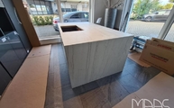 Kücheninsel im Küchenstudio mit Neural Dekton Arbeitsplatte und Wangen