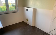 WC-Bereich mit großformatigen Fliesen Moon White an der Wand und Liem Dark auf dem Boden